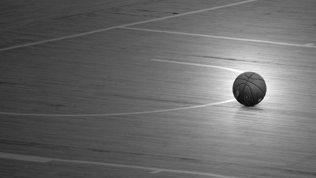 A basketball on an empty basketball court